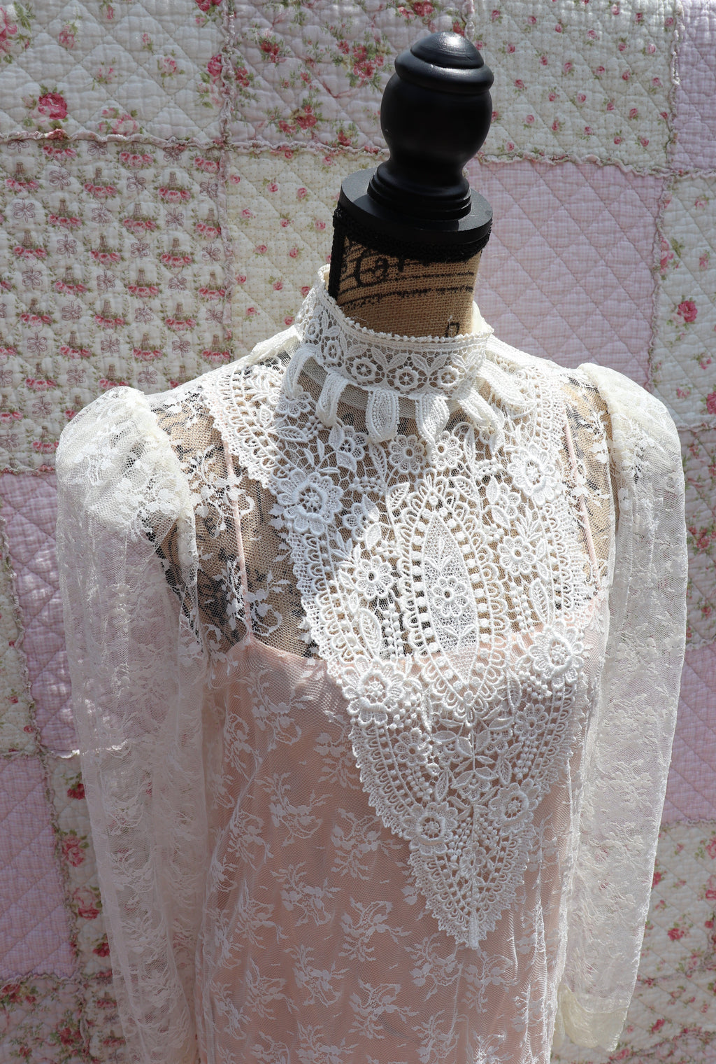 Get the best of both worlds with The Samantha Dress - a mashup of 1920s glamour and 1980s flair from Jessica McClintock. This white drop-waist puff shoulder turtleneck lace dress is laid over a delicate peach silk slip. Two for the price of one! Upgrade your wardrobe with this unique, versatile piece.