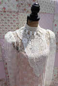 Get the best of both worlds with The Samantha Dress - a mashup of 1920s glamour and 1980s flair from Jessica McClintock. This white drop-waist puff shoulder turtleneck lace dress is laid over a delicate peach silk slip. Two for the price of one! Upgrade your wardrobe with this unique, versatile piece.