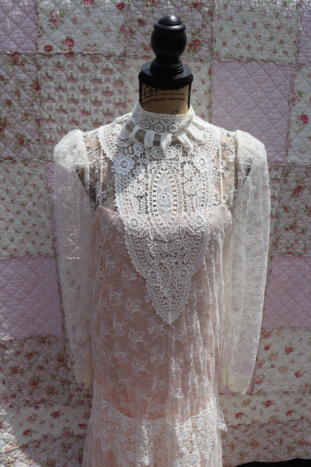 Get the best of both worlds with The Samantha Dress - a mashup of 1920s glamour and 1980s flair from Jessica McClintock. This white drop-waist puff shoulder turtleneck lace dress is laid over a delicate peach silk slip. Two for the price of one! Upgrade your wardrobe with this unique, versatile piece.