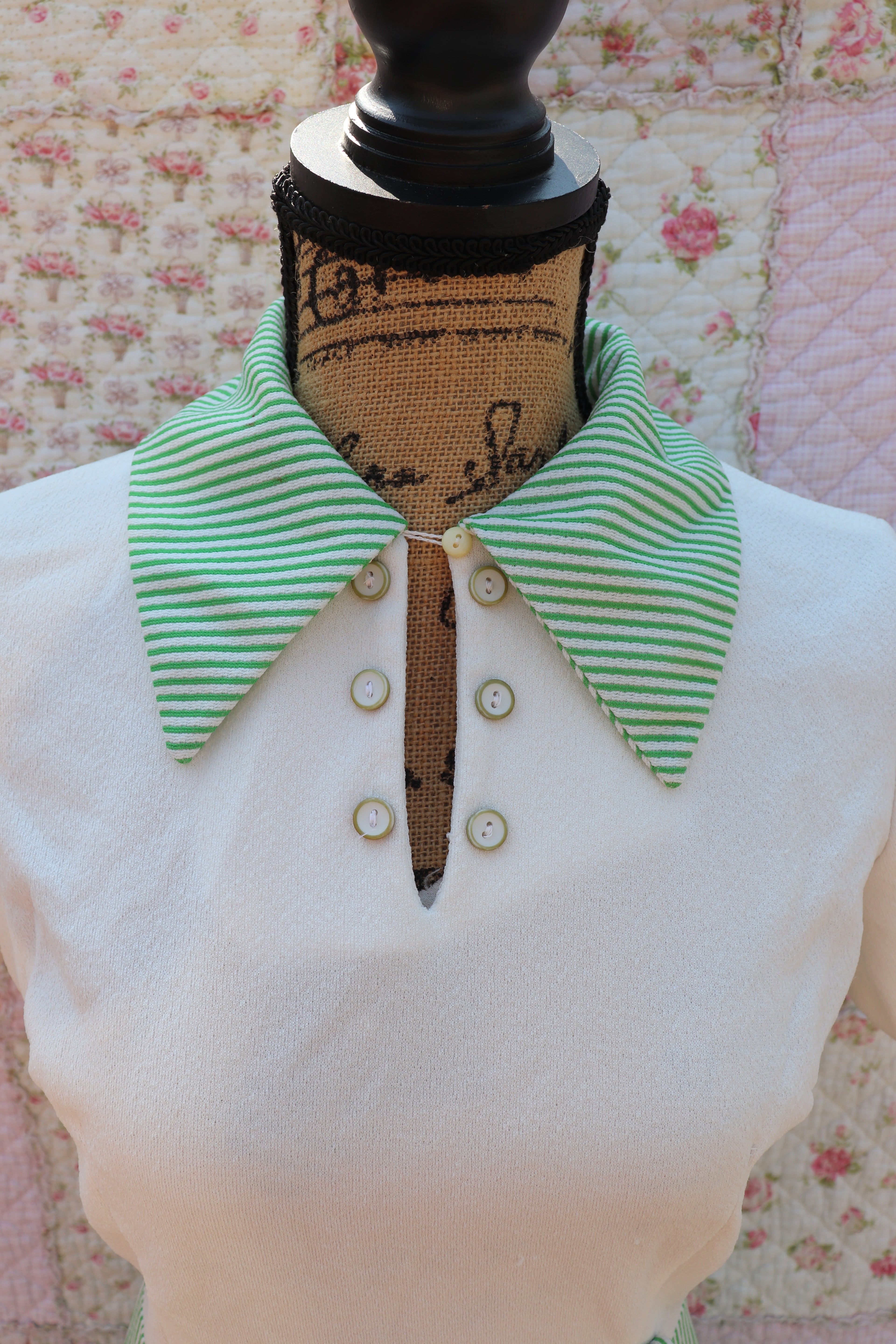 Introducing the Mabel Dress: a playful 1970s throwback. This white terry cloth dress features a green pinstripe skirt and collar, with a small cutout and cream buttons on the neck for added cuteness. Perfect for hitting the courts this summer!
