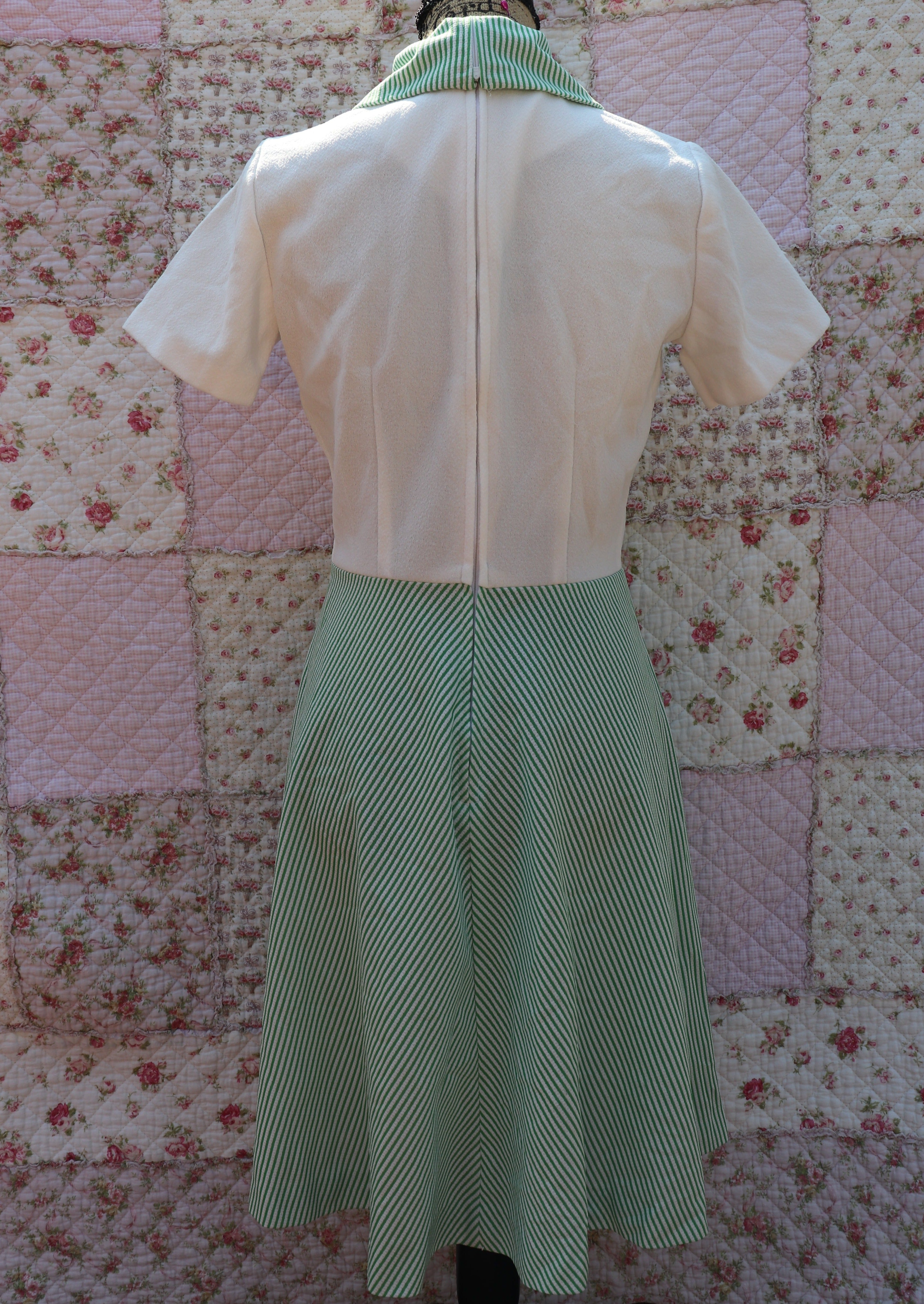 Back view of the mabel dress from the 1970s. This white terry cloth dress features a green pinstripe skirt and collar, with a small cutout and cream buttons on the neck for added cuteness. Perfect for hitting the courts this summer!