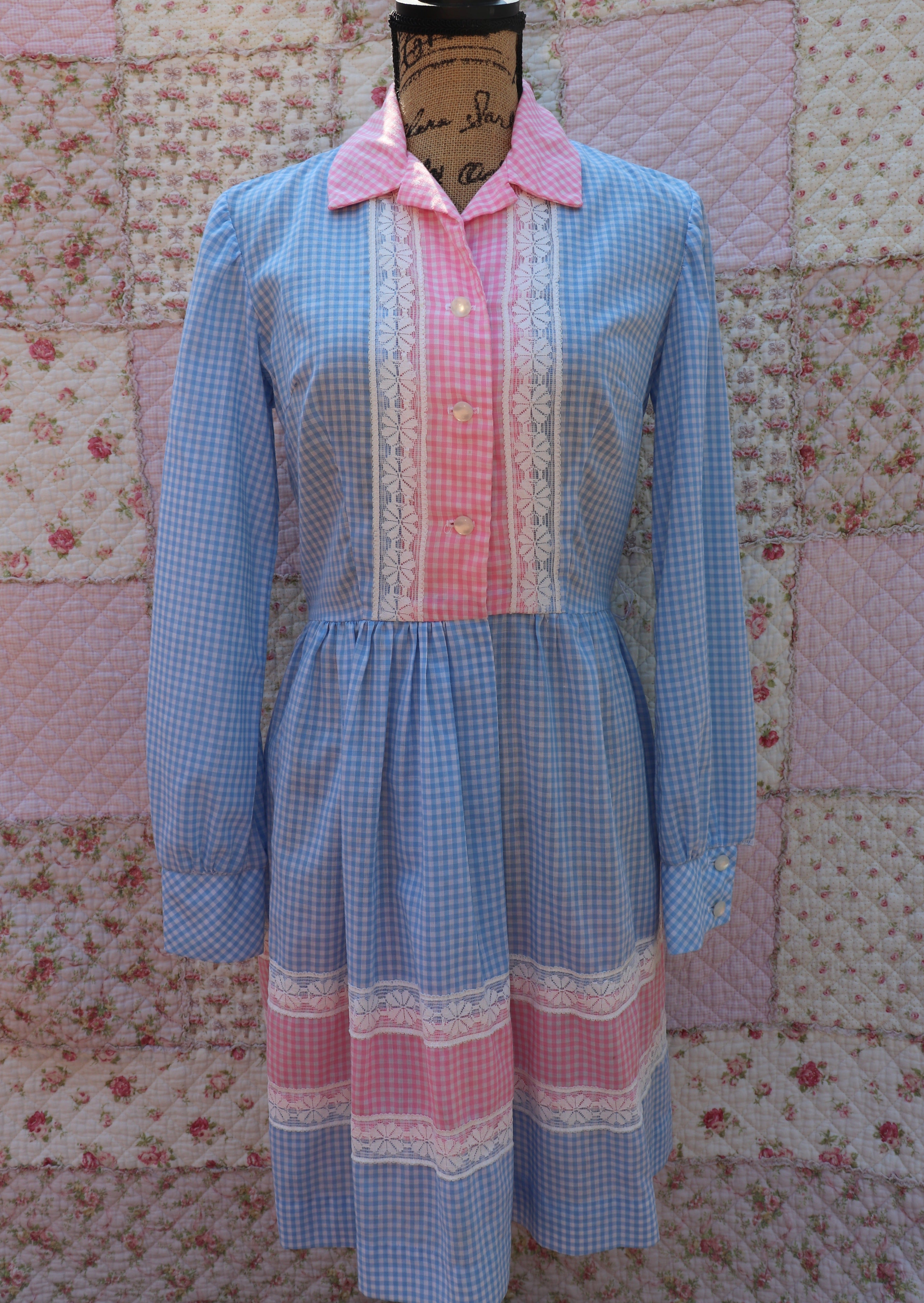 Soak up the sun in the iris dress from J&J Classics! This 1960s dress features a playful blue and white gingham print, accented with pink and white gingham. The long sleeves and collar add a touch of sophistication, while delicate floral lace details add a hint of sweet charm. Get ready to turn heads and spread some flower power with this dress!