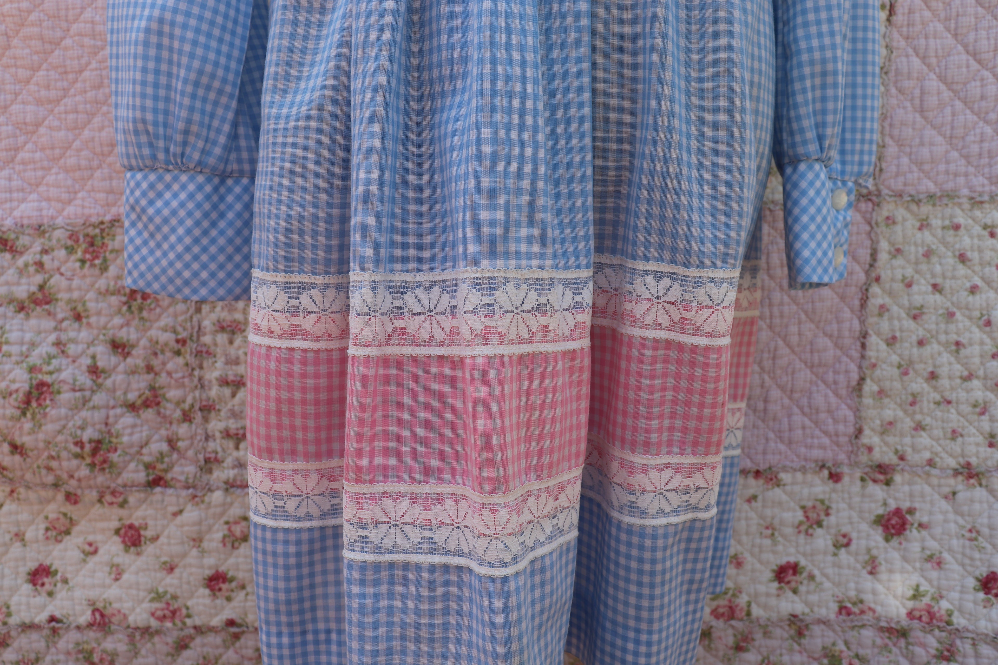 Soak up the sun in the iris dress from J&J Classics! This 1960s dress features a playful blue and white gingham print, accented with pink and white gingham. The long sleeves and collar add a touch of sophistication, while delicate floral lace details add a hint of sweet charm. Get ready to turn heads and spread some flower power with this dress!