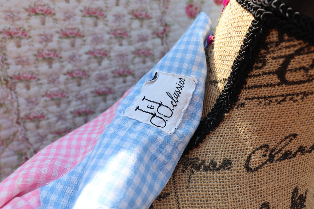View of a J&J Classics tag from the 1960s. This 1960s dress features a playful blue and white gingham print, accented with pink and white gingham. The long sleeves and collar add a touch of sophistication, while delicate floral lace details add a hint of sweet charm. Get ready to turn heads and spread some flower power with this dress!