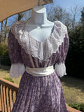 Float like a fairy in the faye dress! This gorgeous purple 1970s Gunne Sax dress is adorned with a dainty white floral pattern and crisp white lace trim. The button front adds an extra touch of unique fun and the attached white ribbon belt adds an extra touch of glamor. Marked as a size 9.