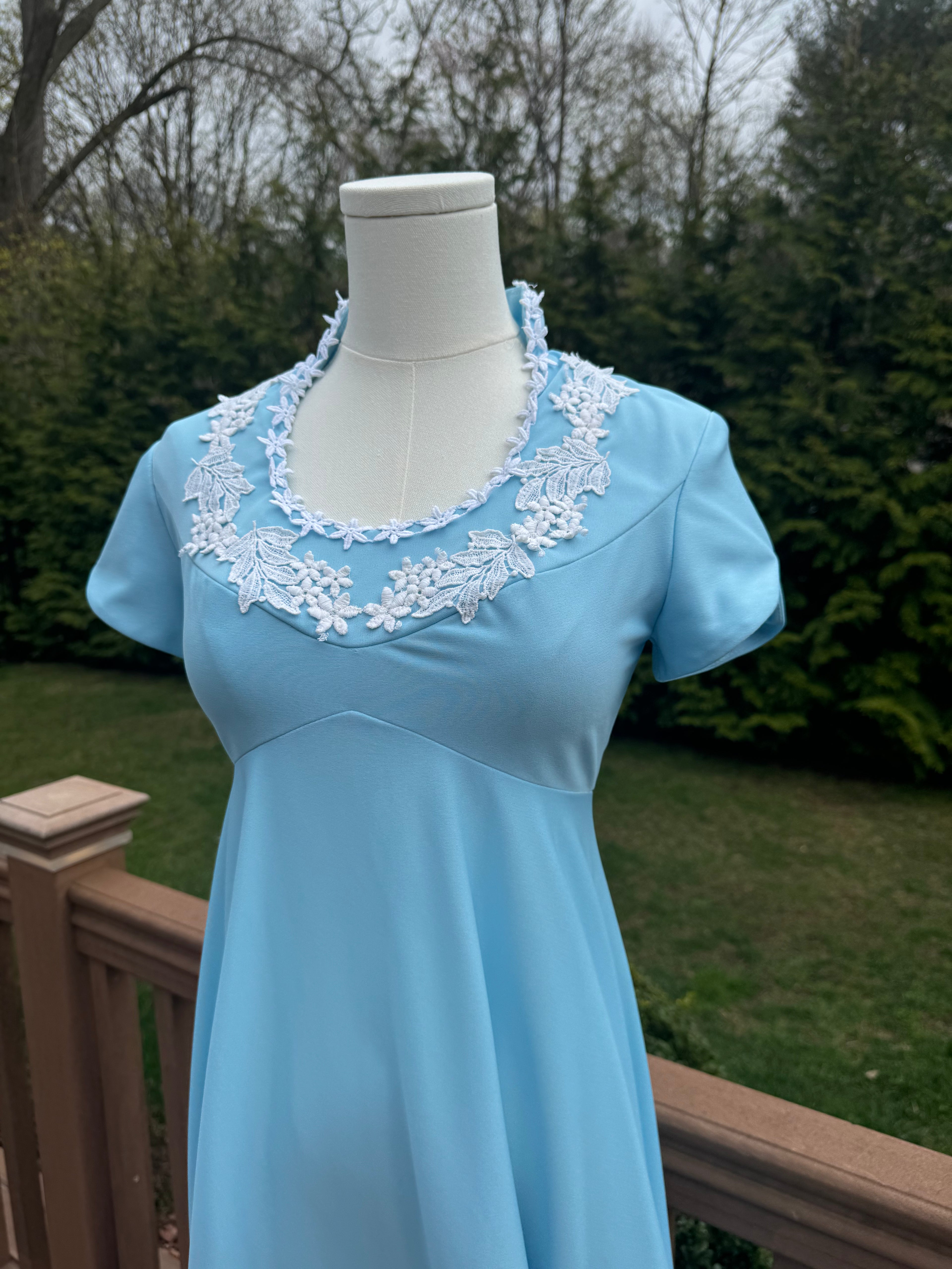 Be bold and turn heads in the jenna dress! This vintage empire waist gown features a bright blue color with playful white appliqué details. Homemade with a gorgeous 1970s silhouette, it is perfect for standing out at any summer event!