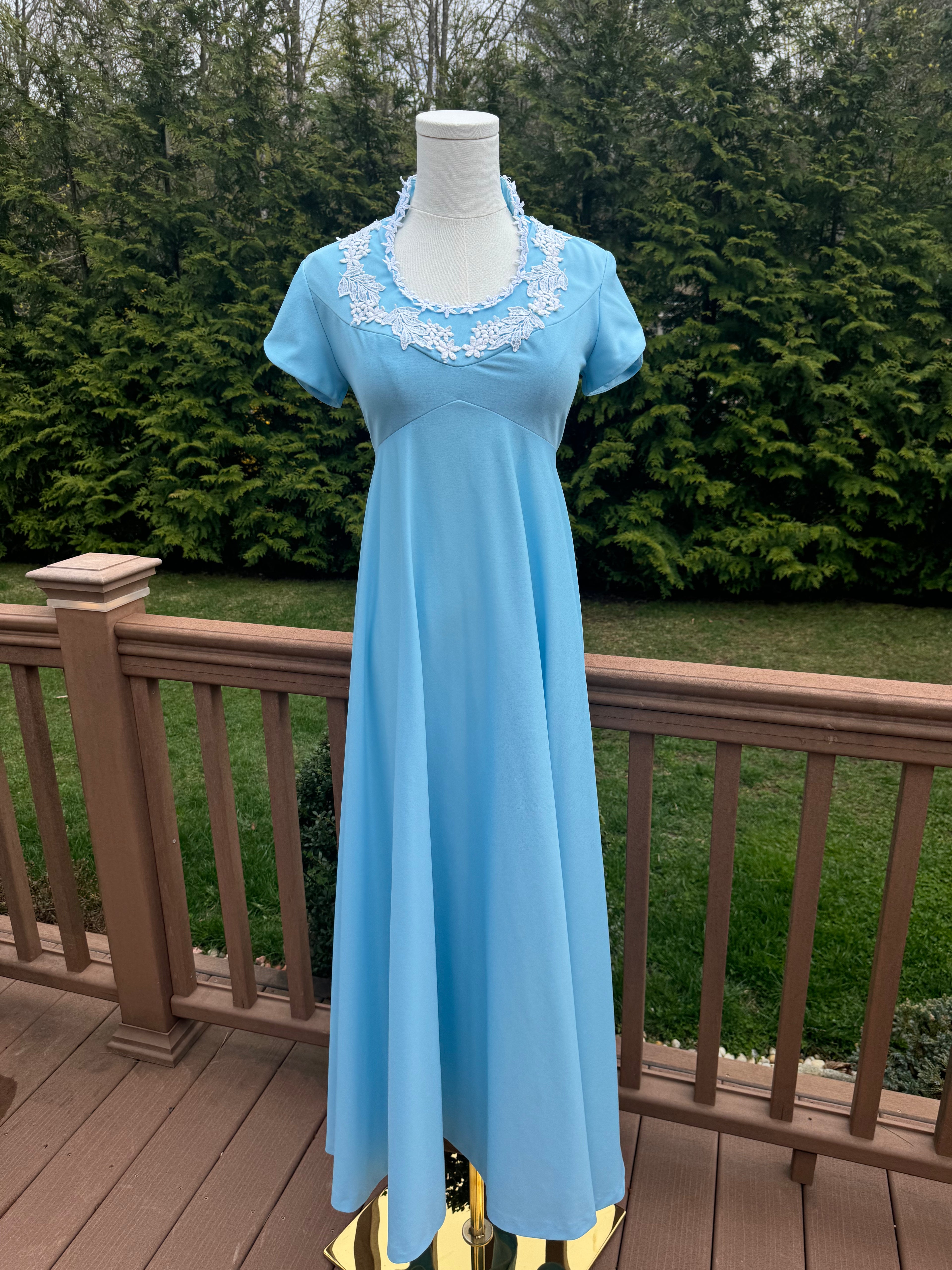 Be bold and turn heads in the jenna dress! This vintage empire waist gown features a bright blue color with playful white appliqué details. Homemade with a gorgeous 1970s silhouette, it is perfect for standing out at any summer event!