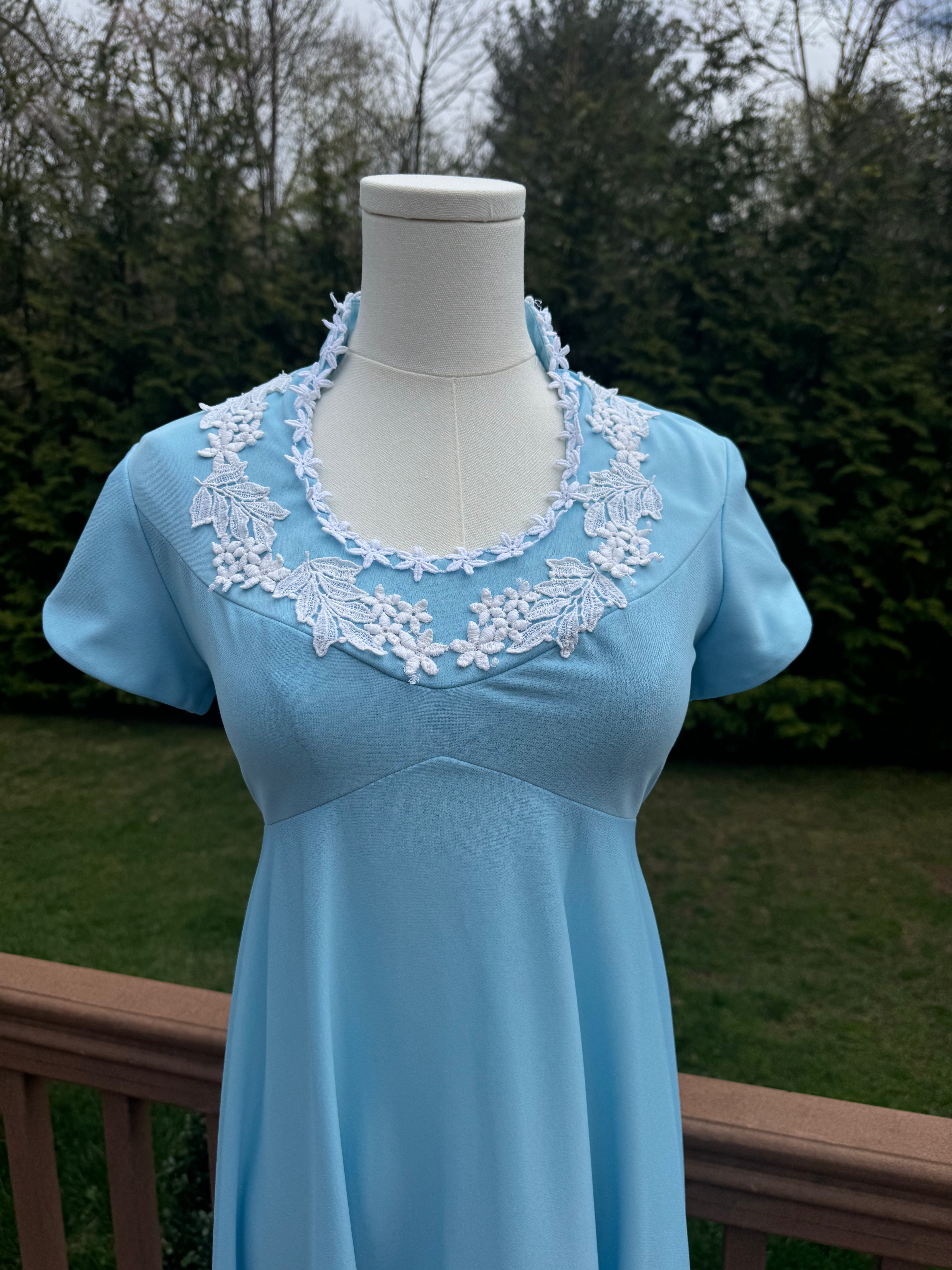 Be bold and turn heads in the jenna dress! This vintage empire waist gown features a bright blue color with playful white appliqué details. Homemade with a gorgeous 1970s silhouette, it is perfect for standing out at any summer event!